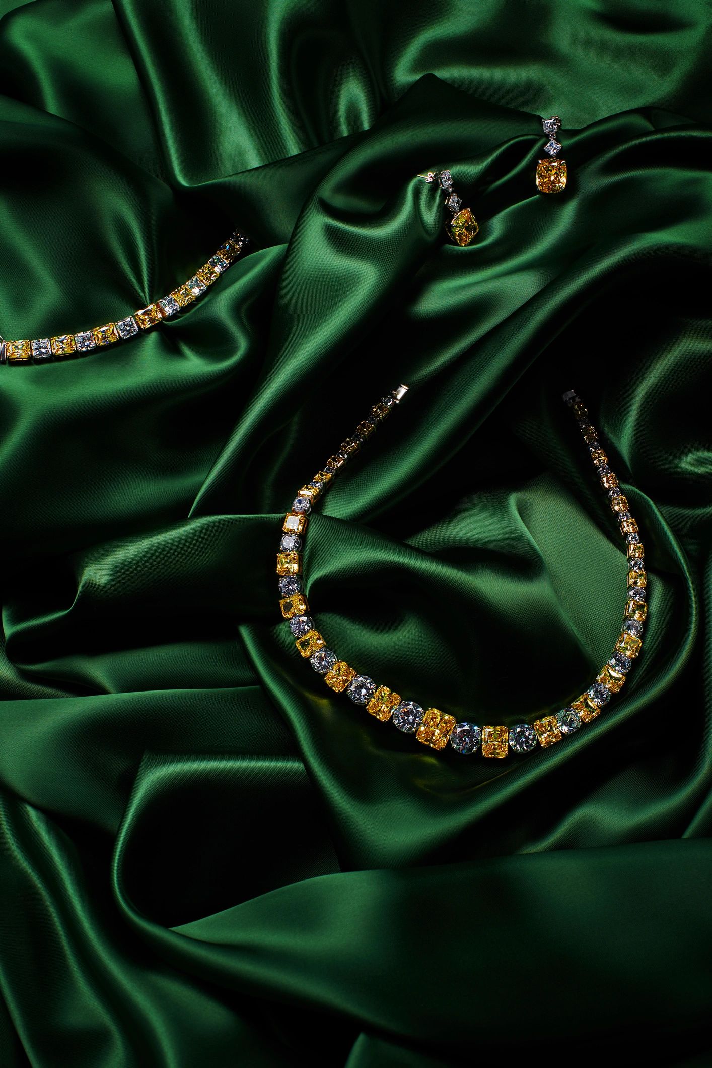 Luxury gold jewelry with gemstones on green silk